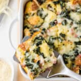 Slice of breakfast strata in a white baking dish.