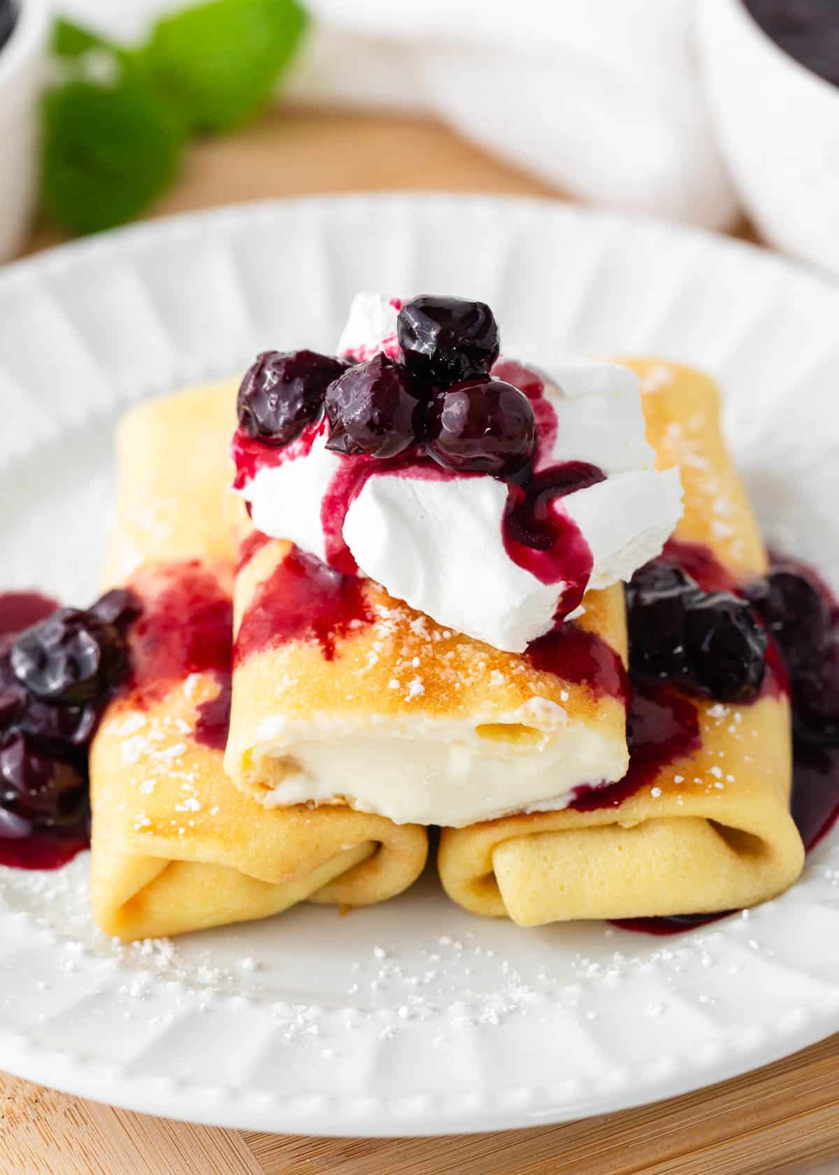 Looking for a unique breakfast experience? Try your hand at making cheese blintzes! Learn how to make these stuffed delights for your next cozy breakfast or brunch at home. Cheese Blintzes on a plate.