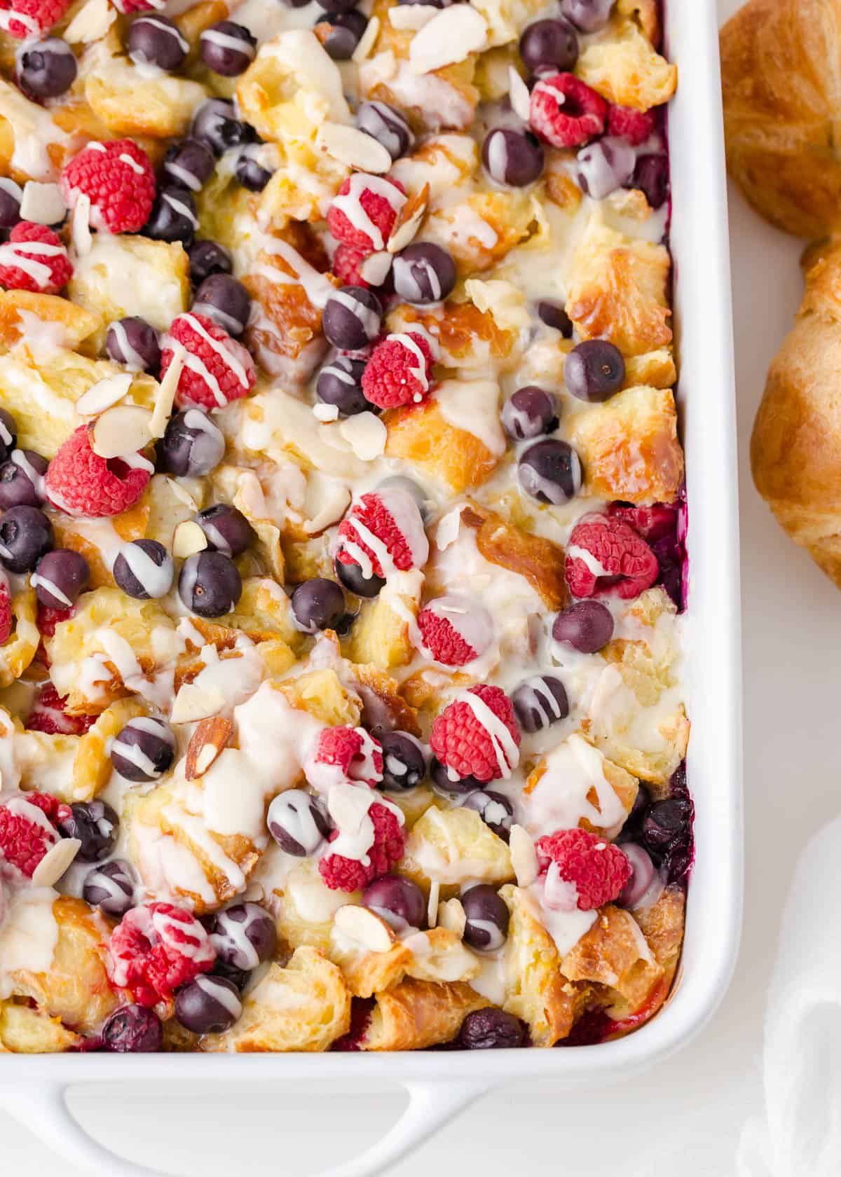 Croissant breakfast casserole in a white baking dish.