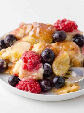 Croissant breakfast casserole with berries on a plate.