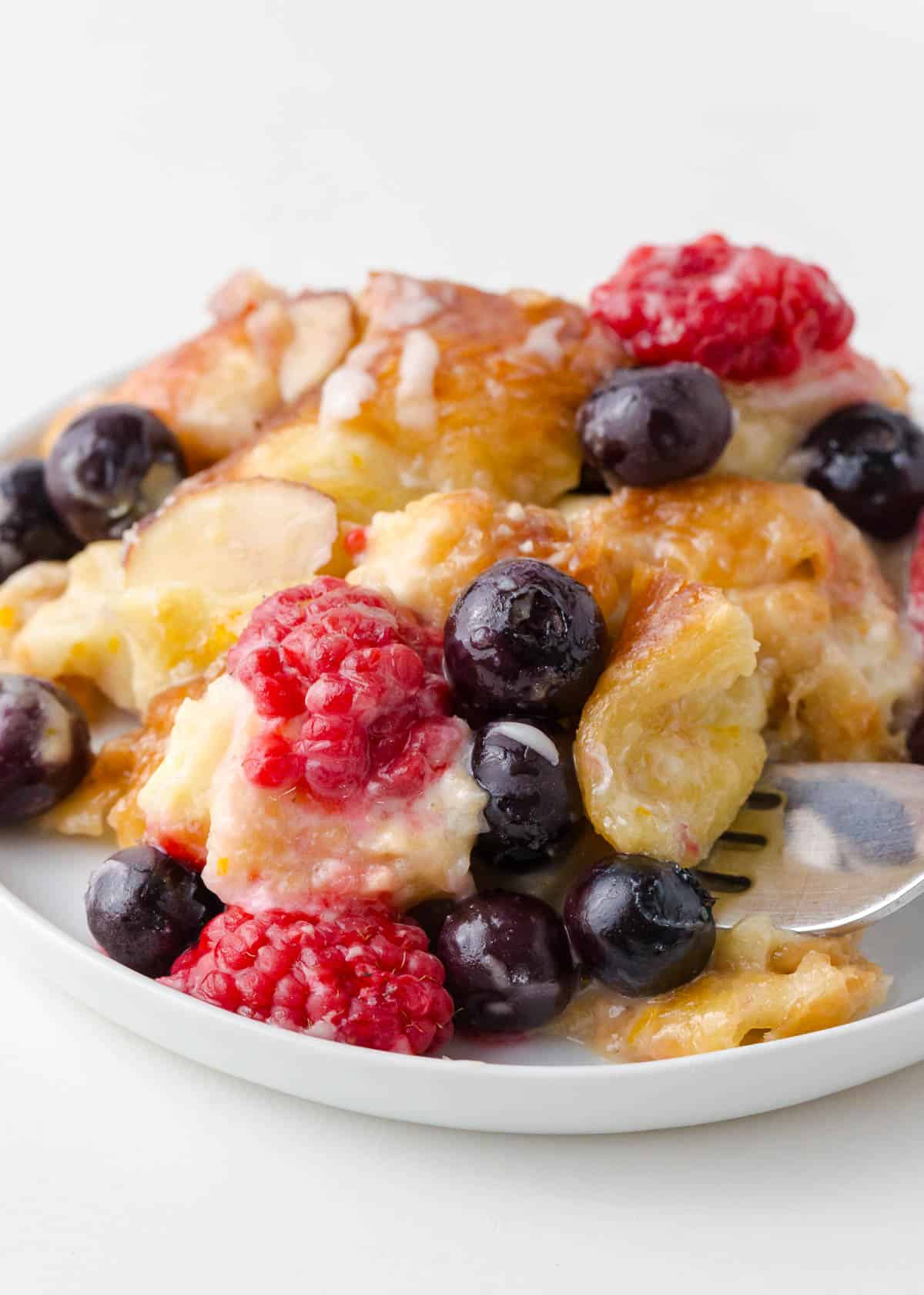 Croissant breakfast casserole with berries on a plate.