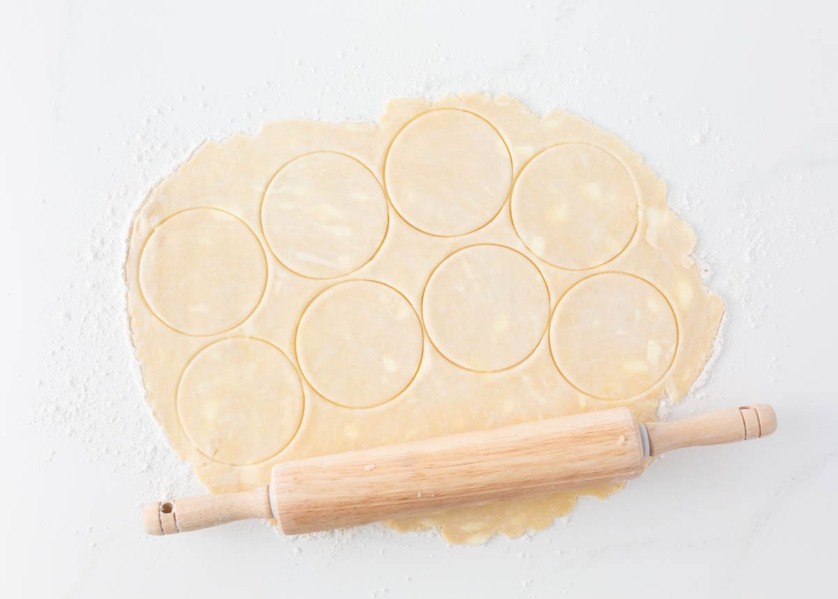 Rolling dough onto the counter.