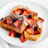 Brioche french toast with berries on a plate.