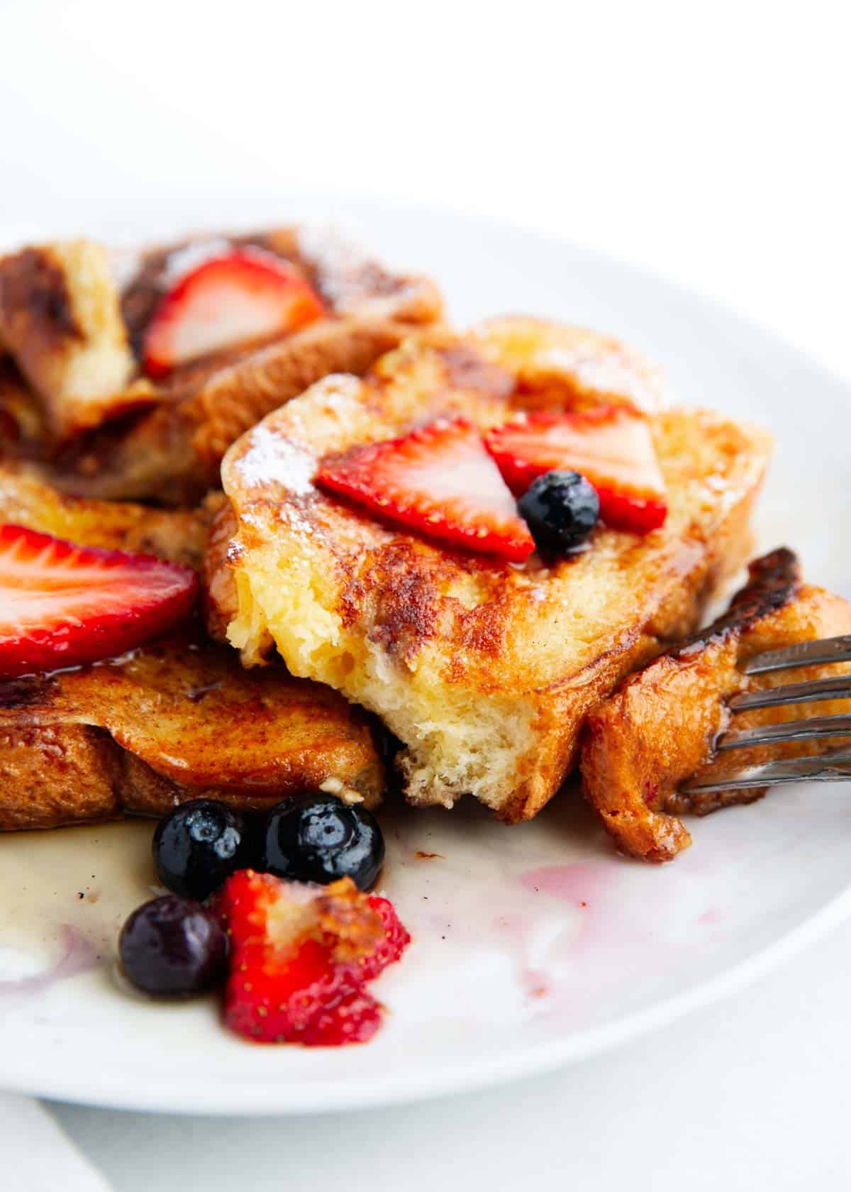 Best brioche french toast with berries on a plate.