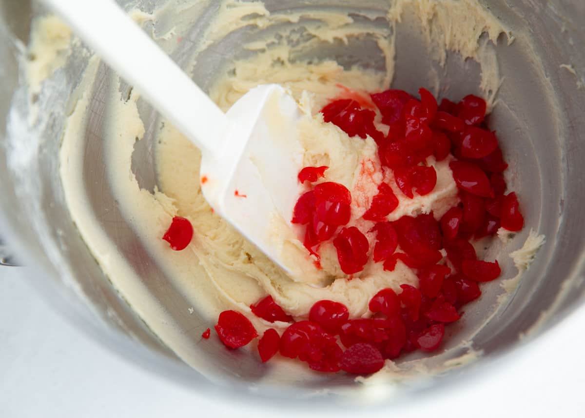 Mixing cherries into dough.