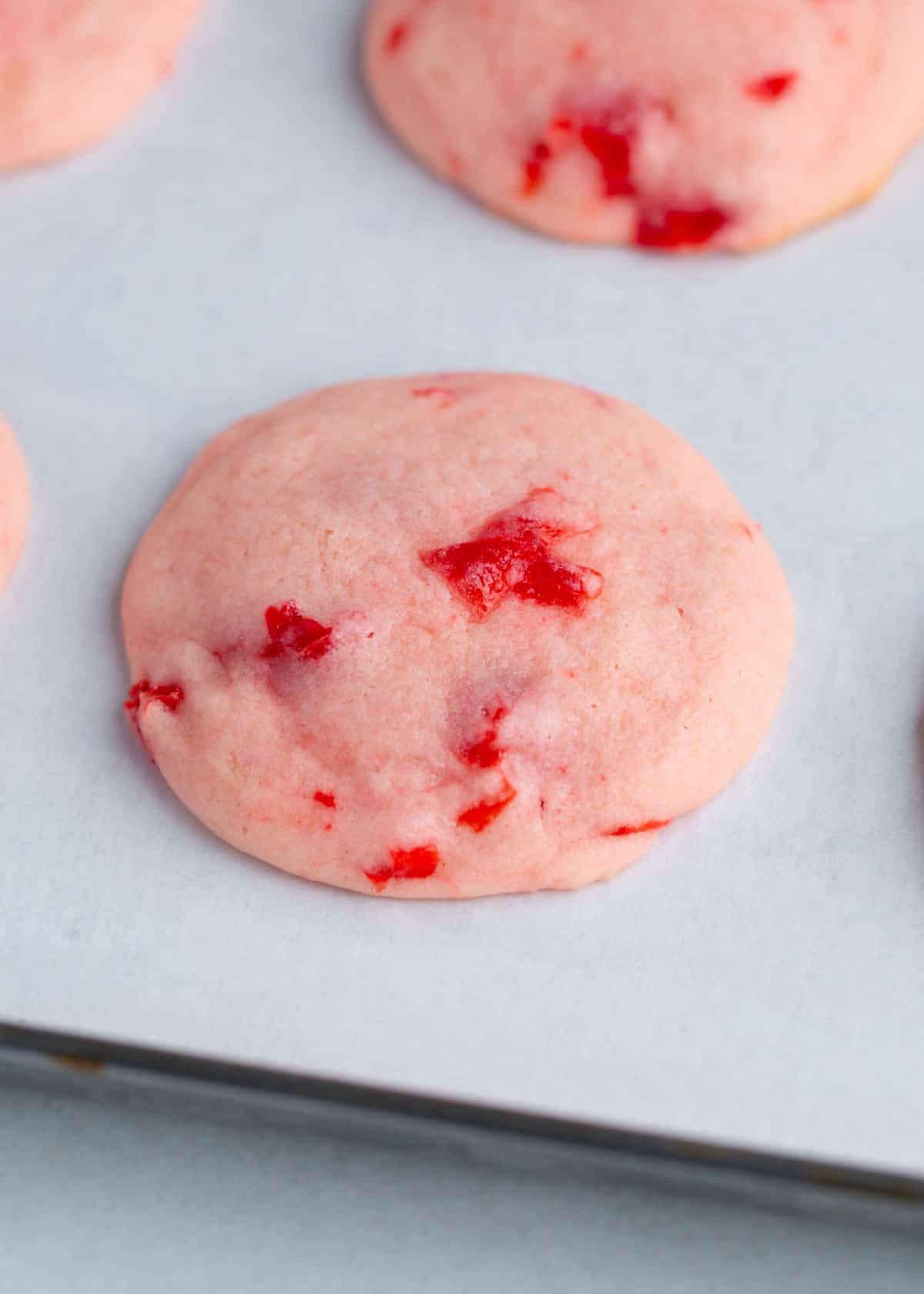 Cherry cookies on a baking sheet.