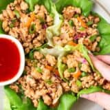 Thai chicken lettuce wraps with sauce on the side.