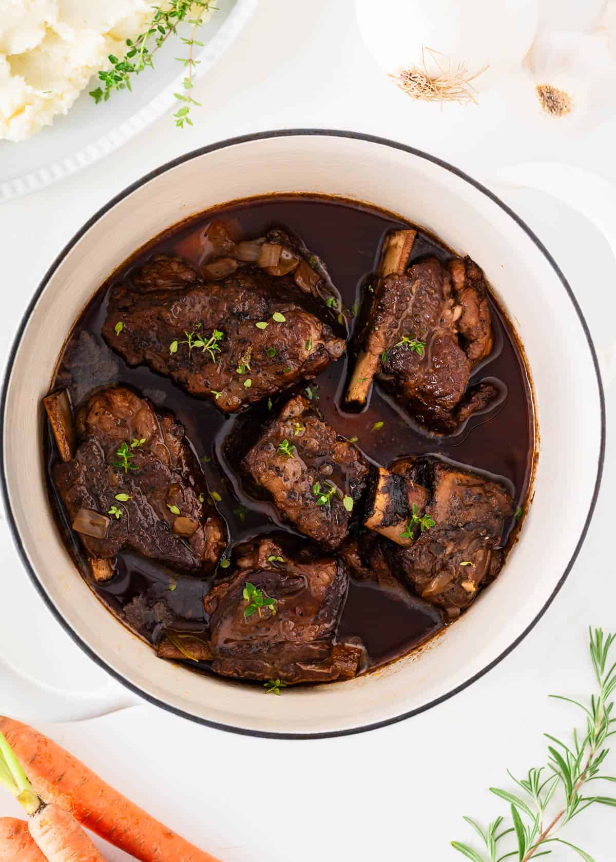 Braised short ribs in a white pot.