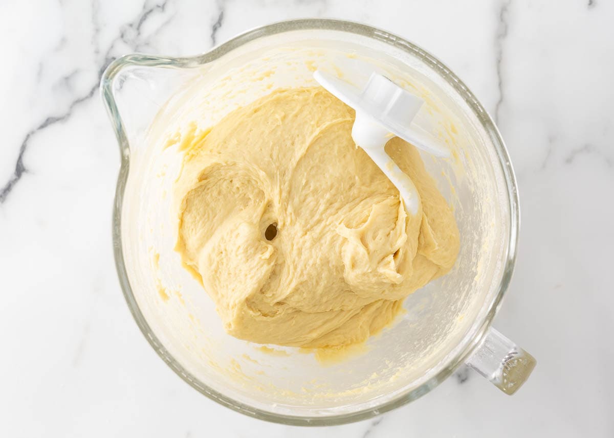 Brioche dough in a bowl with dough hook.