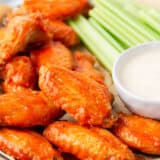 Buffalo wings on a plate with dip.
