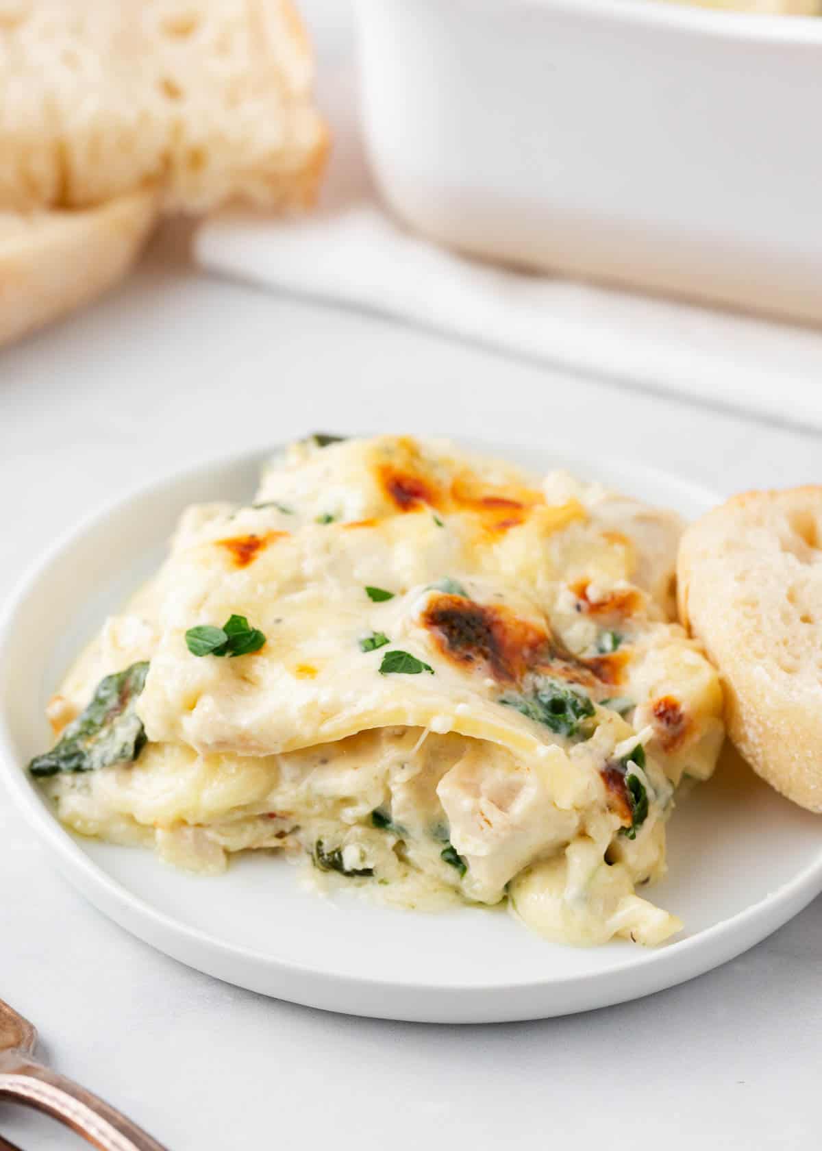 White chicken alfredo lasagna on white plate.