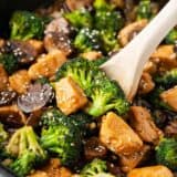 Chicken and broccoli stir fry cooking in a skillet.