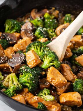 Chicken and broccoli stir fry cooking in a skillet.