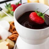 Dipping strawberry into chocolate fondue.