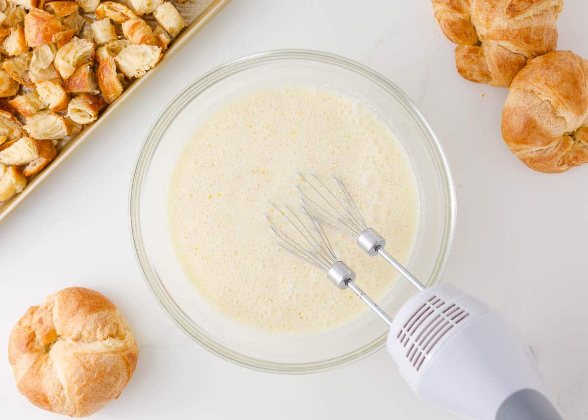 Making the creamy egg mixture for croissant casserole.