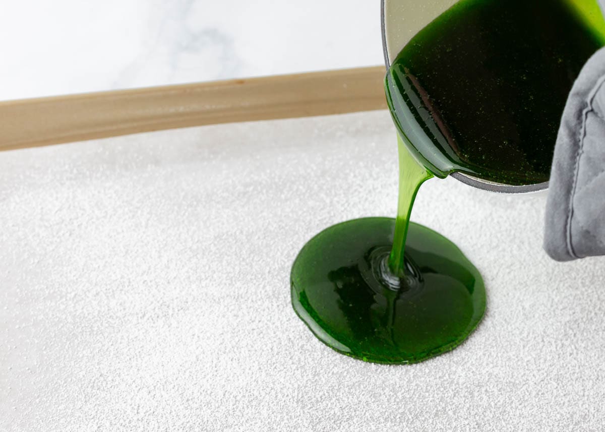 Pouring candy onto a baking sheet.