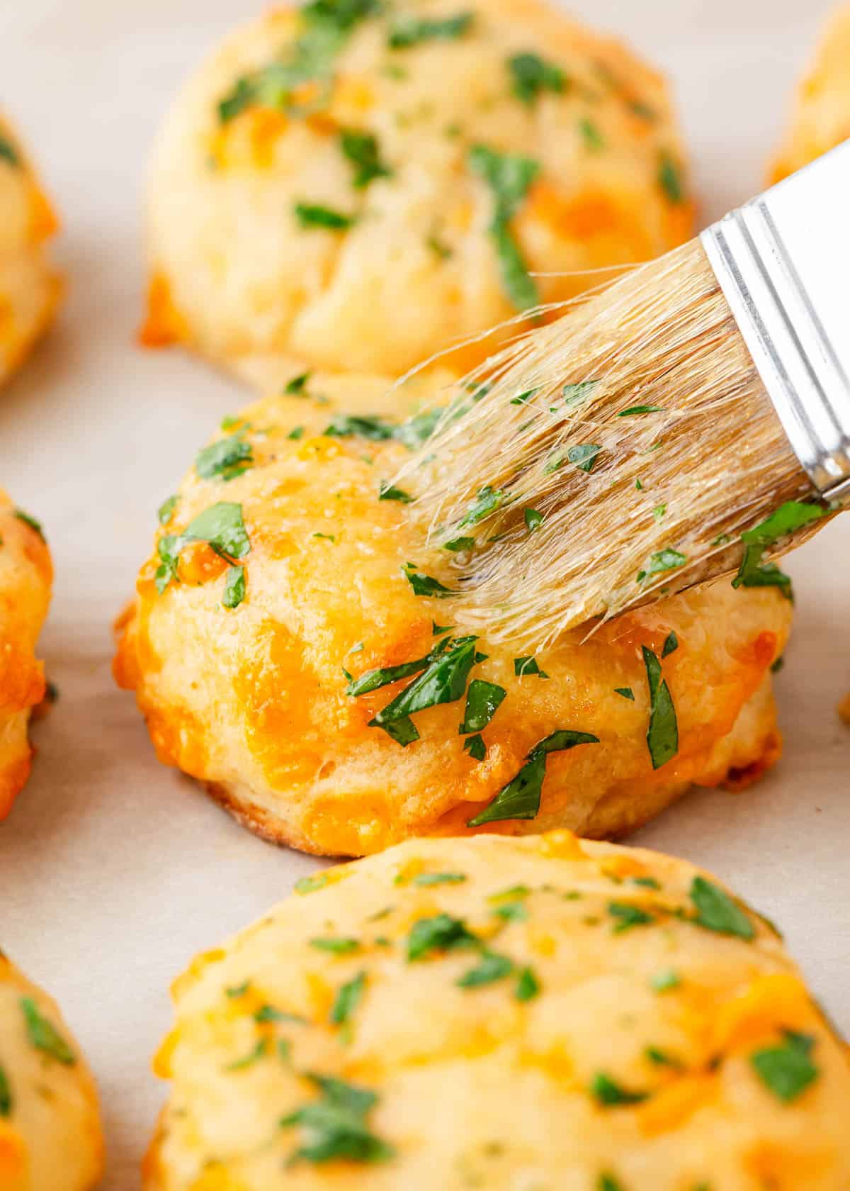 Brushing butter onto Red Lobster Cheddar Bay Biscuits.