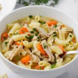 Turkey soup in a white bowl.