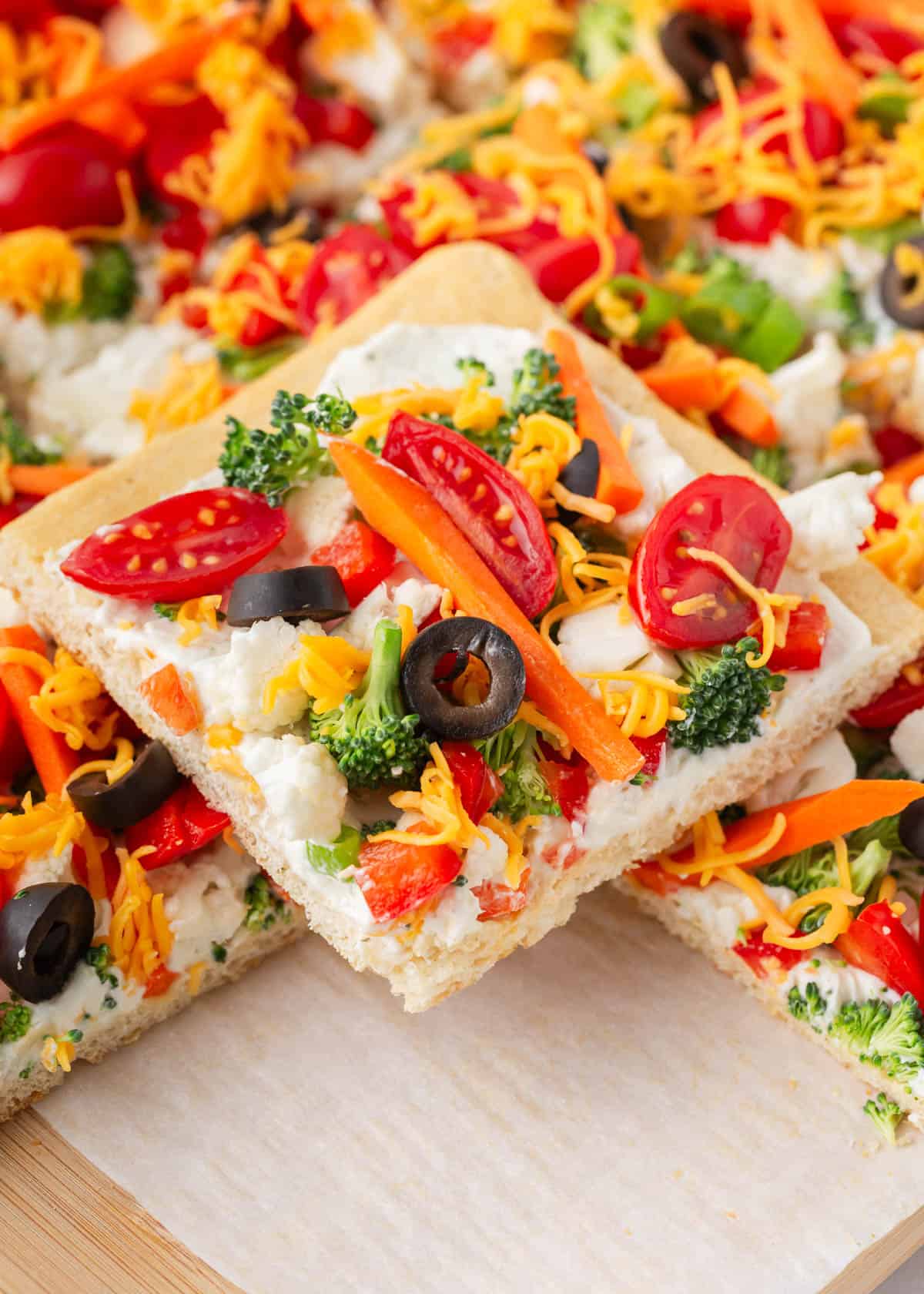 Unroll happiness with our veggie pizza made on a flaky crescent roll crust! Packed with colorful veggies and a tangy creamy sauce, this recipe is a go-to appetizer for any gathering! Slice of the best veggie pizza.