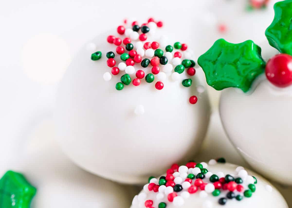 These Christmas Oreo balls are easy to make with crushed Oreos and cream cheese. Dipped in white chocolate and decorated with sprinkles, these truffles look elegant on any cookie exchange tray and are an irresistible holiday treat! Christmas oreo balls.