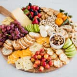 Fruit and cheese platter on a wooden platter.