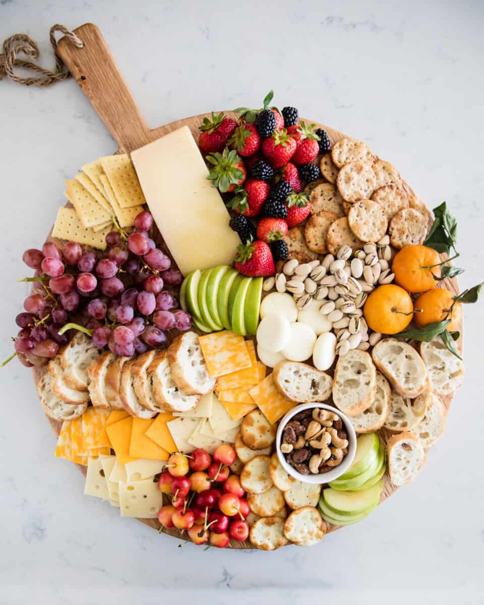 Fruit and cheese platter on a wooden board.
