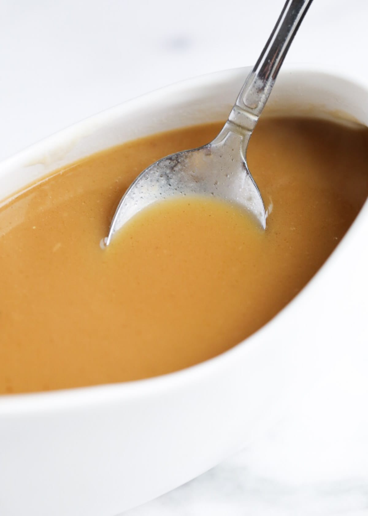 Homemade gravy in a white dish.