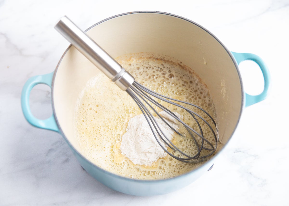 Whisking flour in a pot.