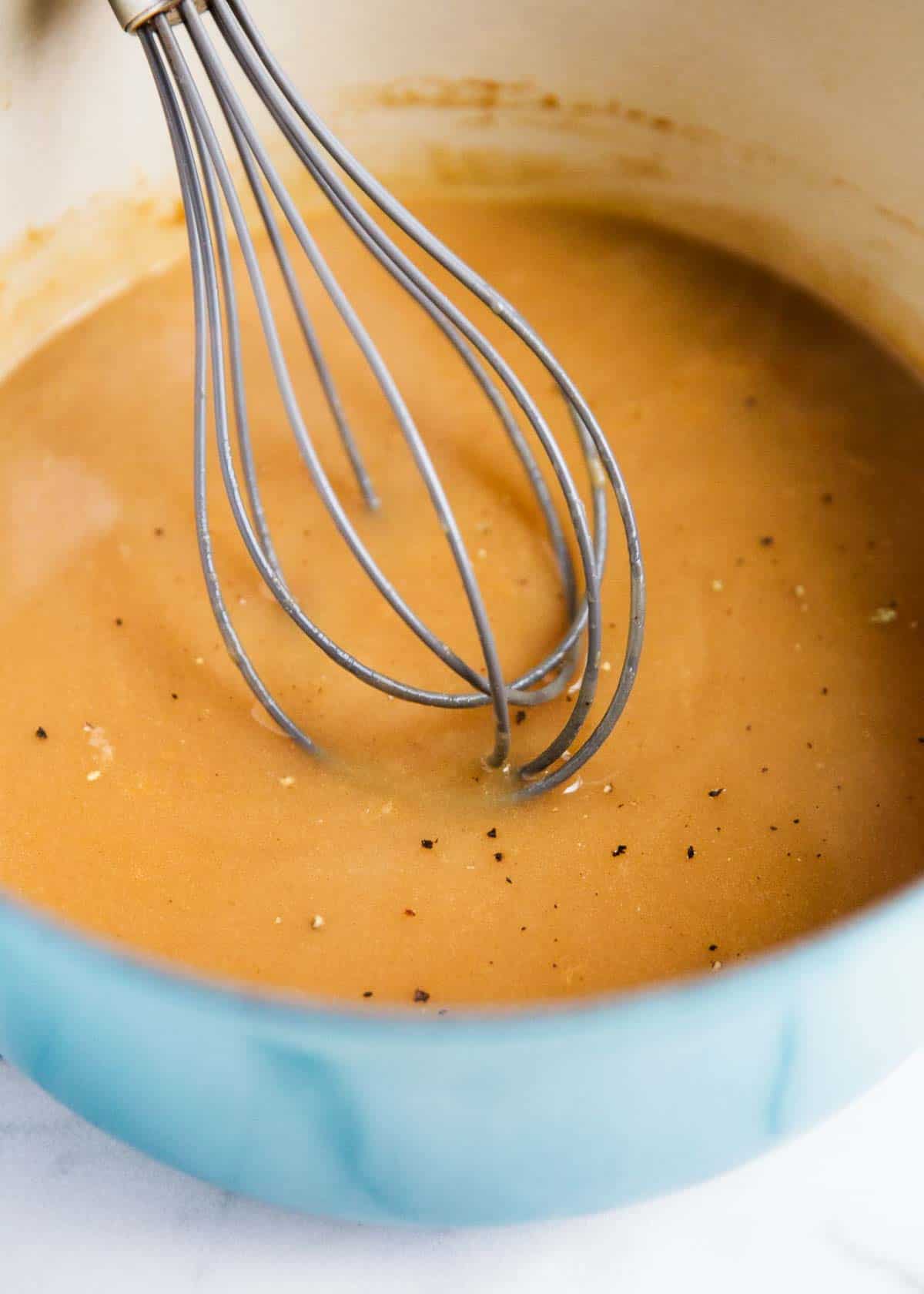 Whisking gravy in a pot.