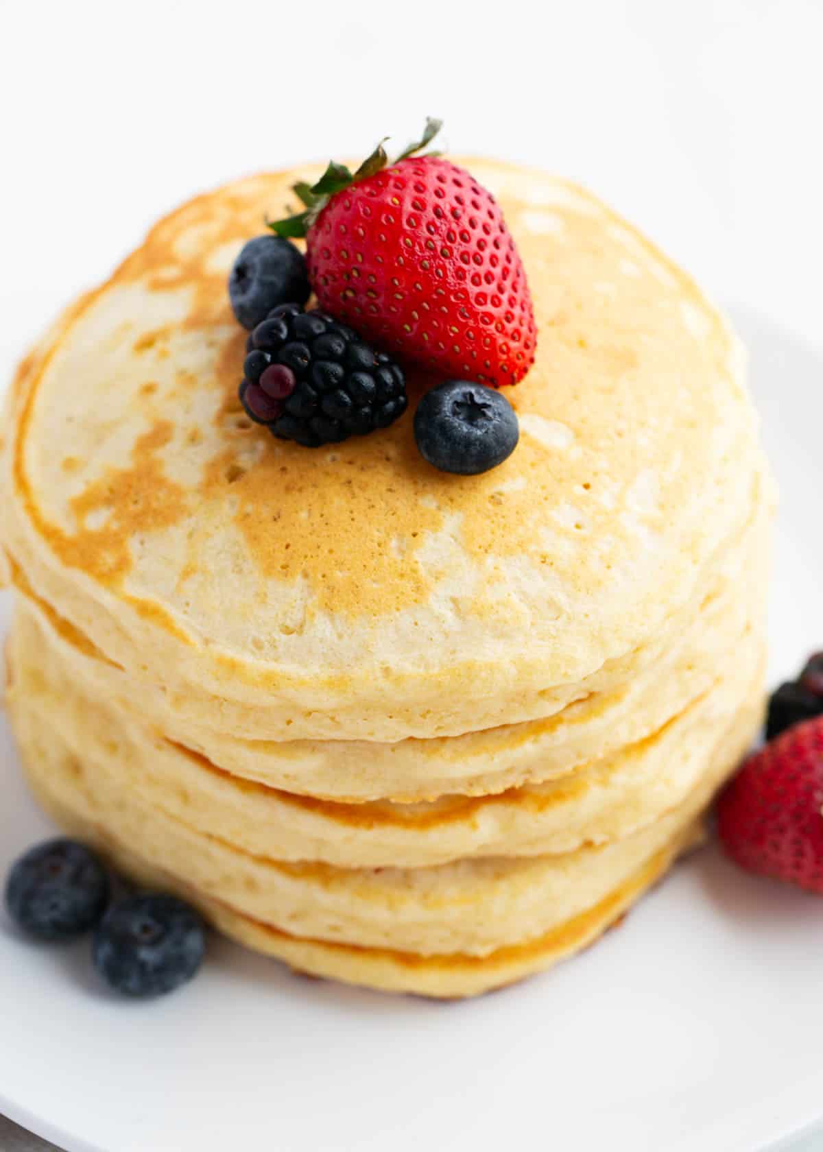 Stack of pancakes on a white plate.