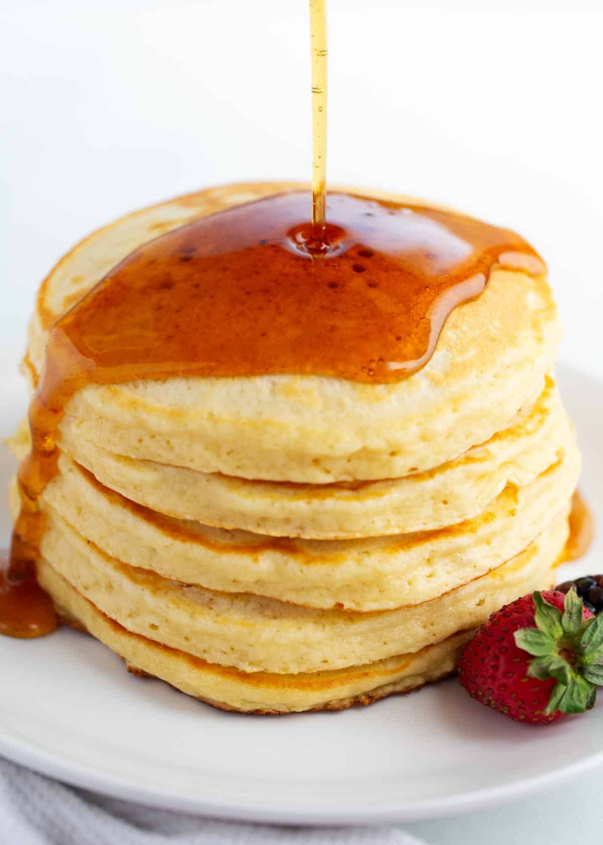 Pouring syrup over my favorite pancake recipe.