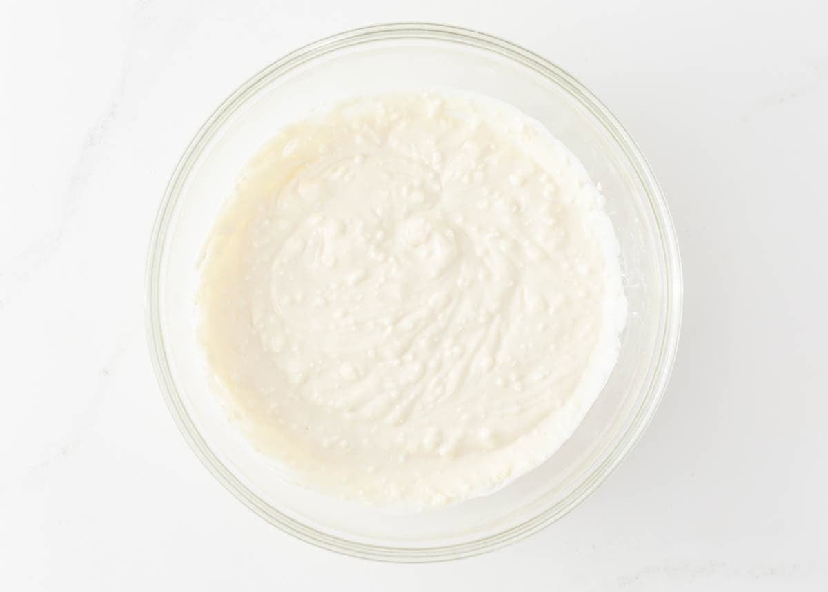 Sweet ricotta and cream cheese filling for cheese blintzes mixed smooth in a glass bowl.