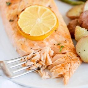 Baked salmon on a plate with veggies.