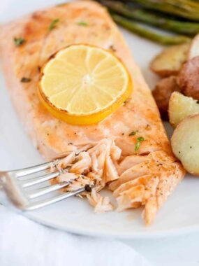 Baked salmon on a plate with veggies.