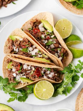 Barbacoa tacos on a plate.
