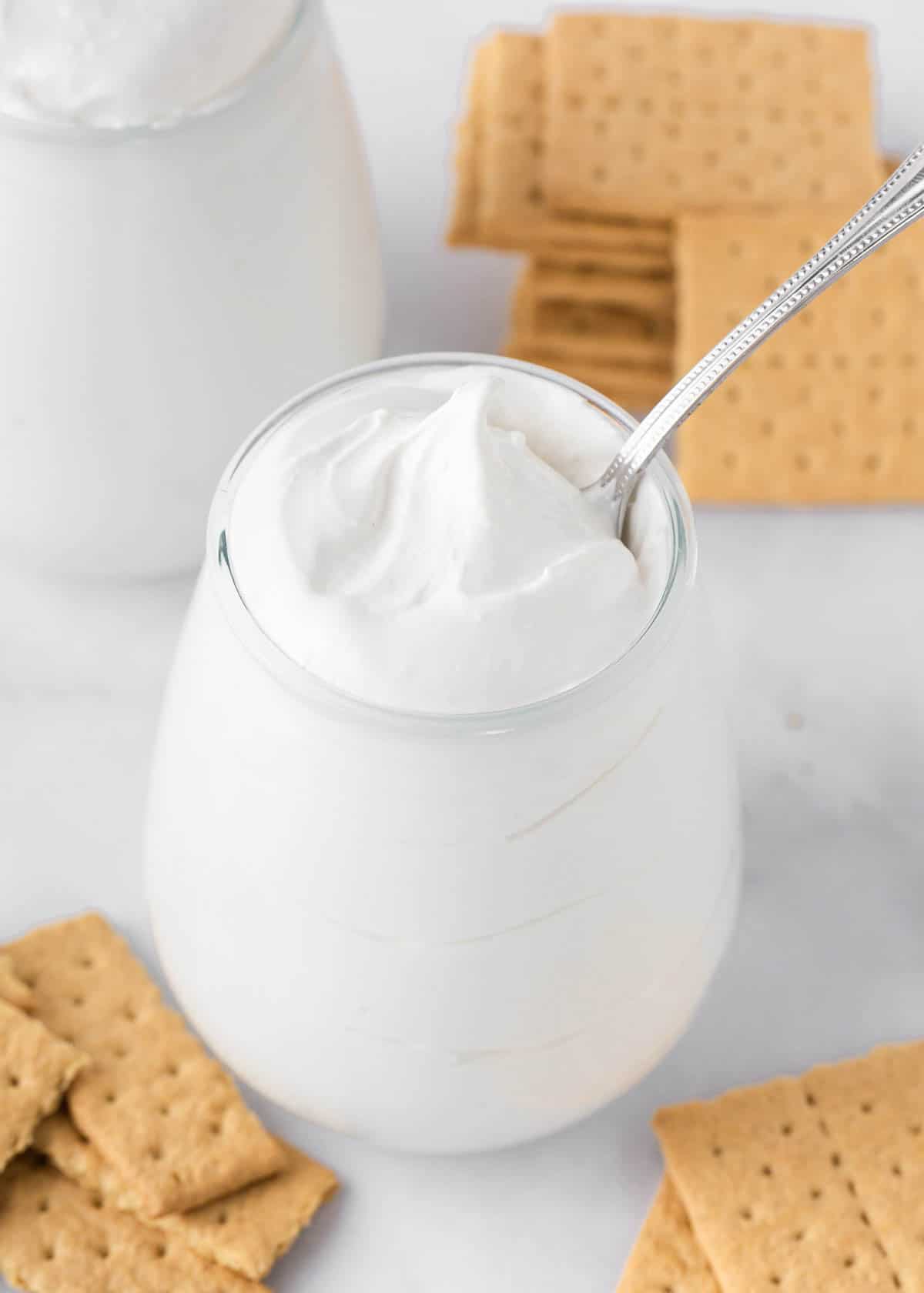 Marshmallow fluff in a jar with graham crackers.