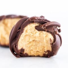 Close-up of a chocolate-dipped peanut butter ball with a bite taken out, showing the creamy peanut butter center.