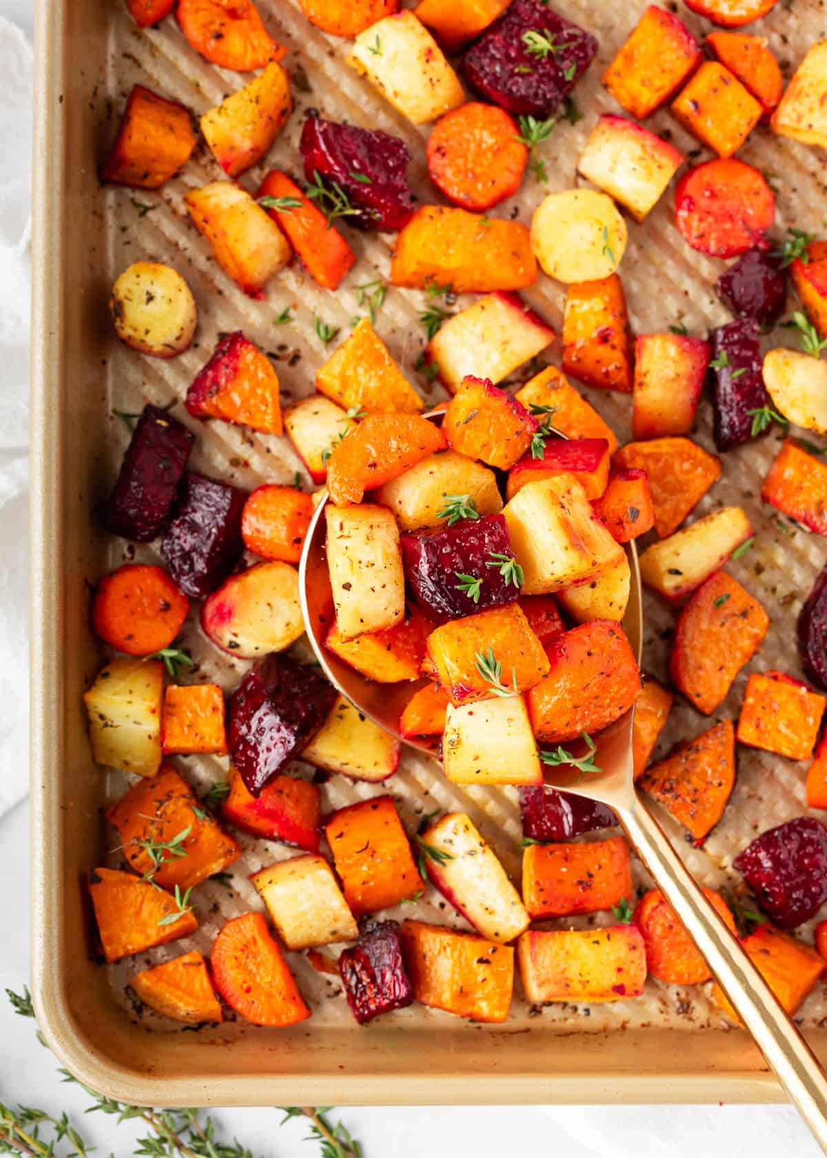 Roasted root vegetables cooking on a baking sheet.