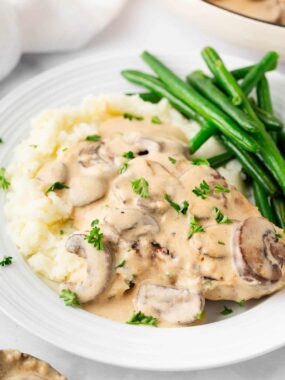 Smothered pork chops with mashed potatoes and green beans.