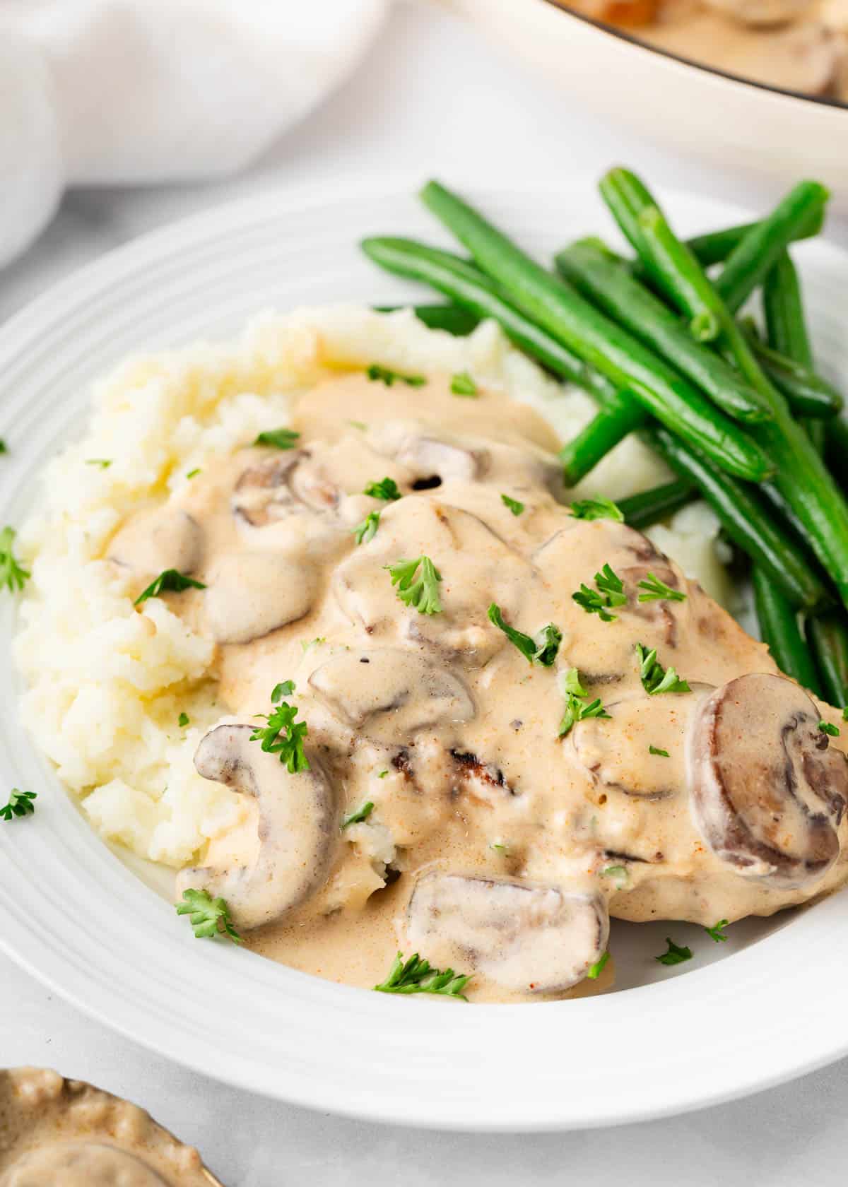 Smothered pork chops with mashed potatoes and green beans.