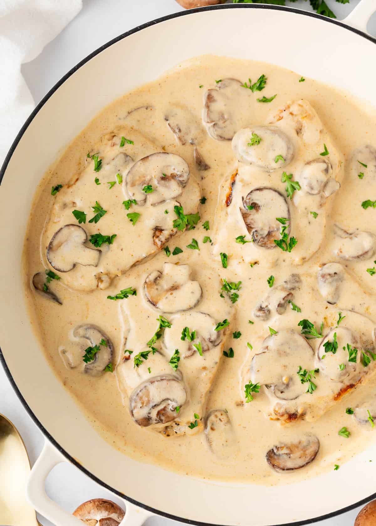 Smothered pork chops cooked in a skillet.