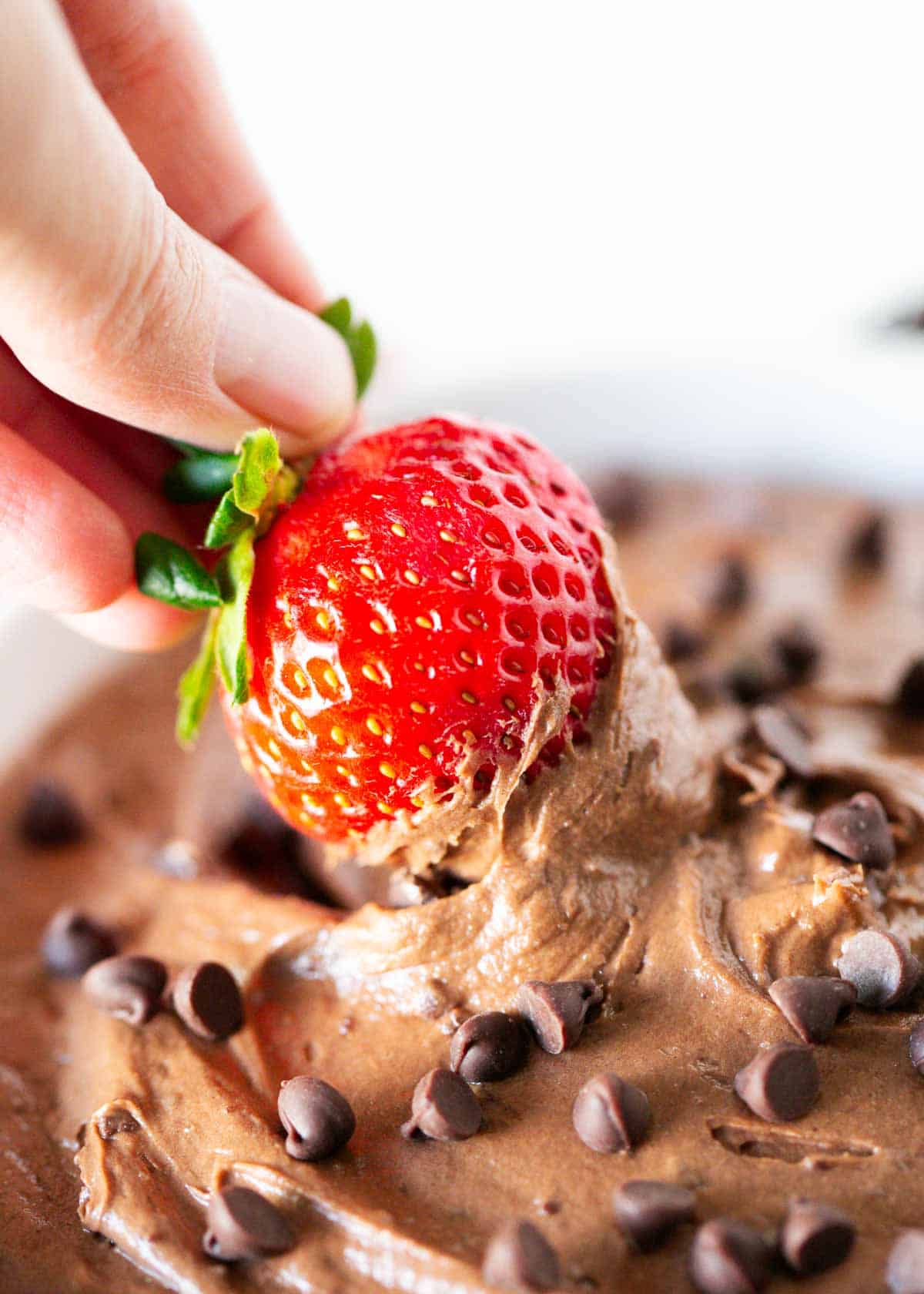 Dipping strawberry into brownie batter dip.