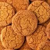 A close up of crispy gingersnap cookies showing the crackly top of the cookie.