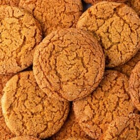 A close up of crispy gingersnap cookies showing the crackly top of the cookie.