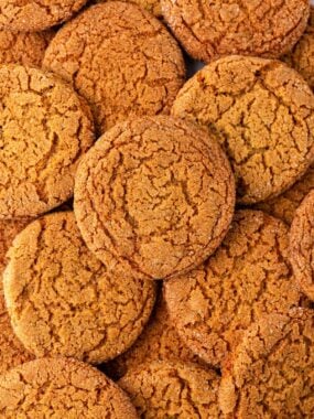 A close up of crispy gingersnap cookies showing the crackly top of the cookie.