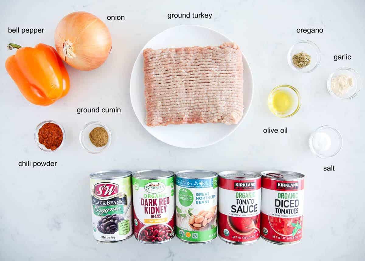 Hearty and flavorful, healthy turkey chili recipe is easy to make on the stovetop or slow cooker with ground turkey, veggies and beans. A comforting bowl of chili is the best for game days or cozy weeknight dinners. Ingredients for healthy turkey chili with ground turkey, three types of beans, tomatoes, bell pepper, onion and seasonings.