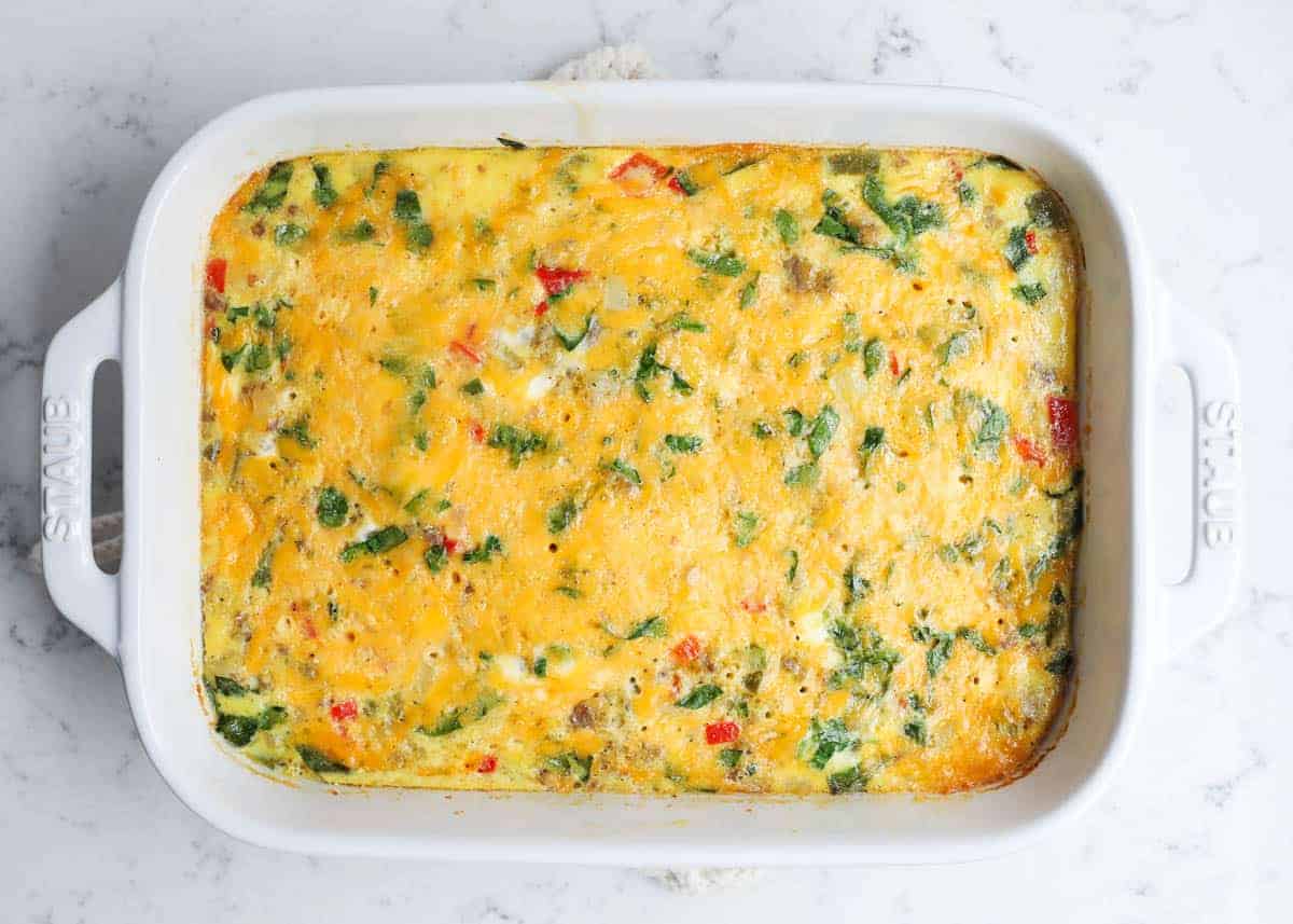 Baked breakfast casserole recipe with melted cheese in a white baking dish.
