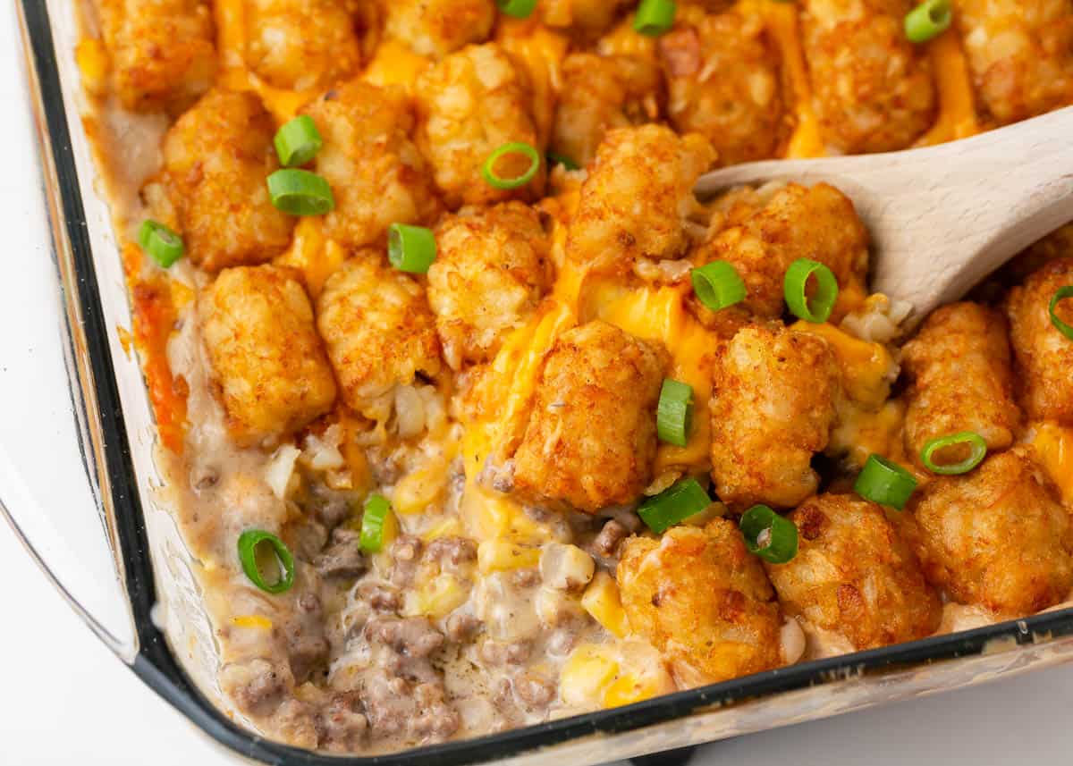 Easy tater tot casserole in a glass dish with spoon.