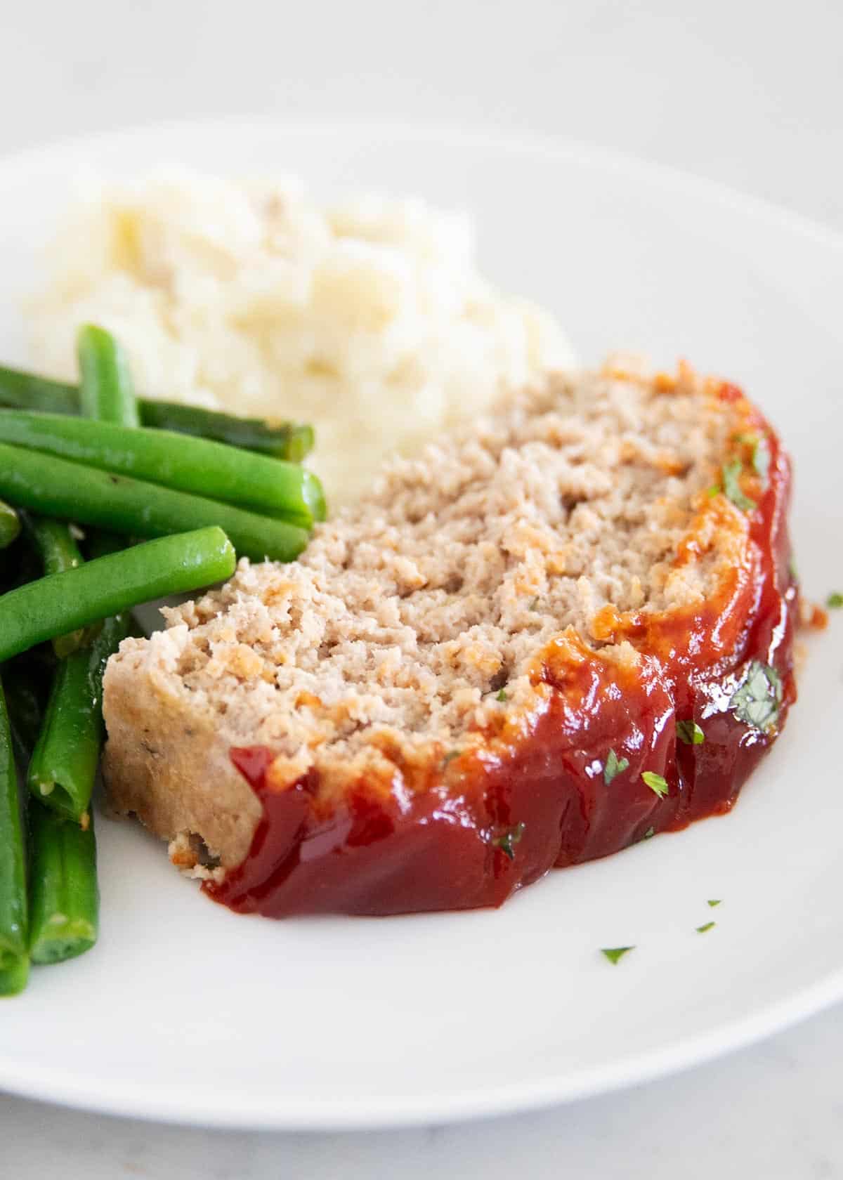 Sliced of turkey meatloaf with mashed potatoes.