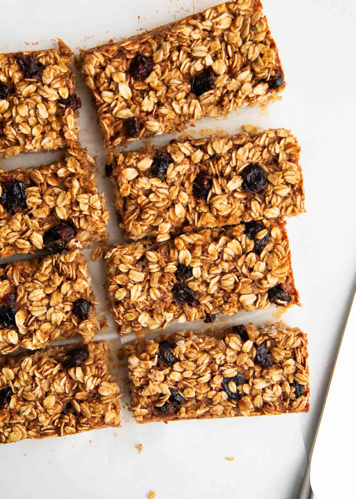 These oatmeal breakfast bars are soft, chewy and a healthy start to the day! They are quick and easy to meal prep in advance for breakfast and snacks. Oatmeal breakfast bars cut into pieces on the counter.